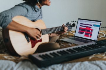 Songwriter playing guitar writing a song